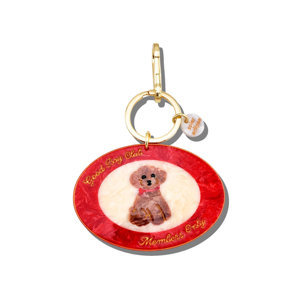 Keychain with a red circular charm featuring an illustration of a dog and text on a white background