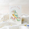 Card with a colorful bird illustration on a white surface