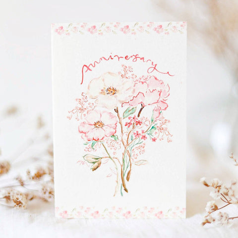 A hand-painted anniversary card featuring a floral design, with a luxury Chantilly white envelope.