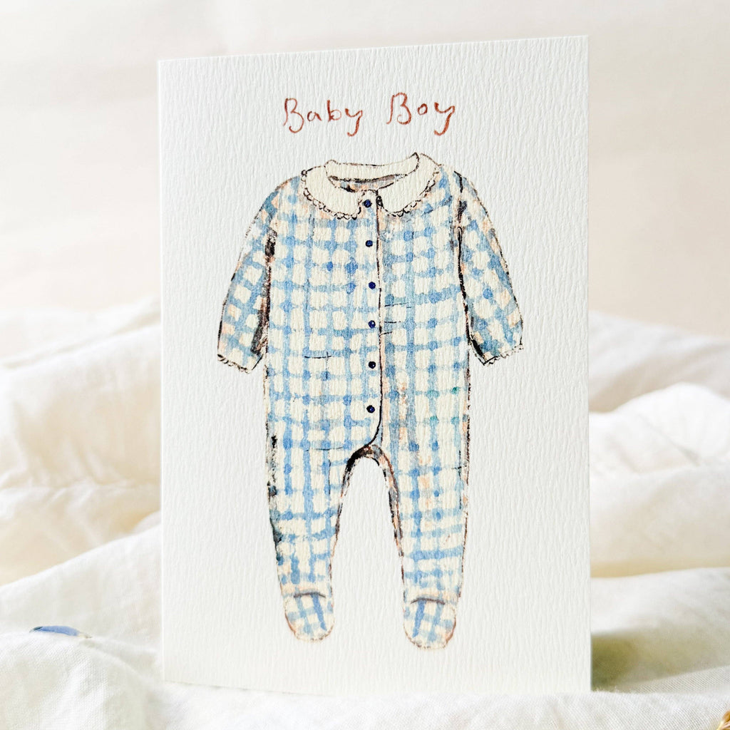 Illustration of a blue checkered baby onesie with 'Baby Boy' text on a white background.