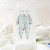 Blue checkered baby onesie on a white card with 'Baby Boy' text, placed on a soft white fabric background.