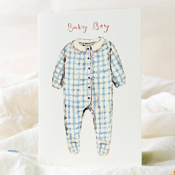 Illustration of a blue checkered baby onesie with 'Baby Boy' text on a white background.