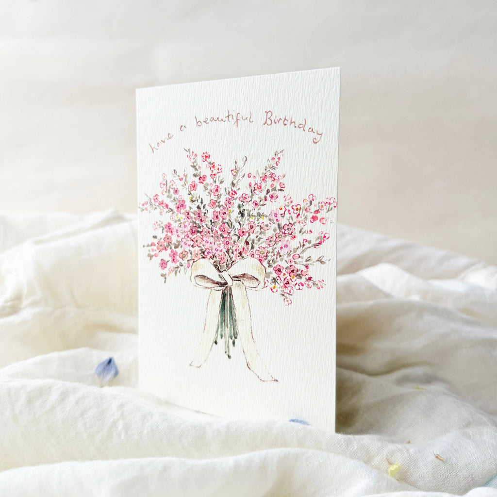 Greeting card with floral design and birthday message on a soft white surface
