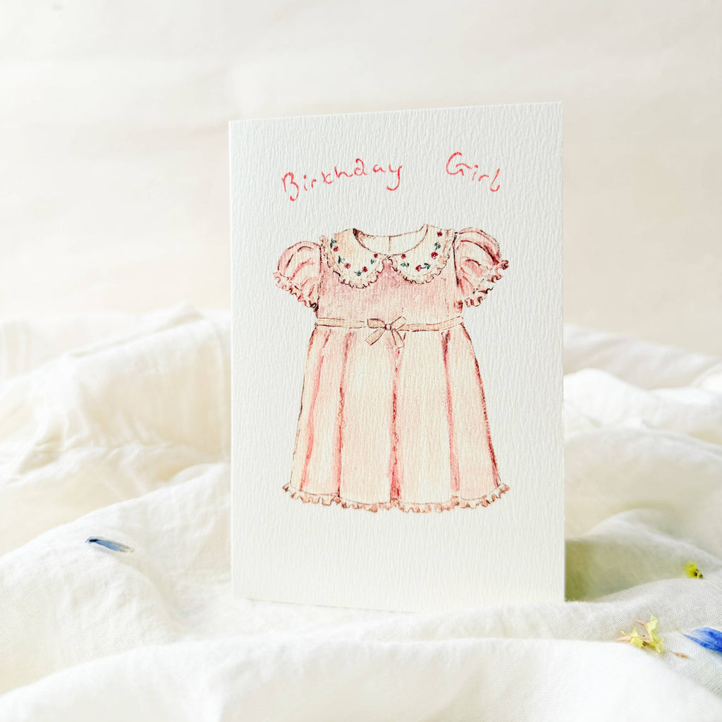 Greeting card with a pink dress illustration and 'Birthday Girl' text on a white background