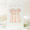 Greeting card with a pink dress illustration and 'Birthday Girl' text on a white background.