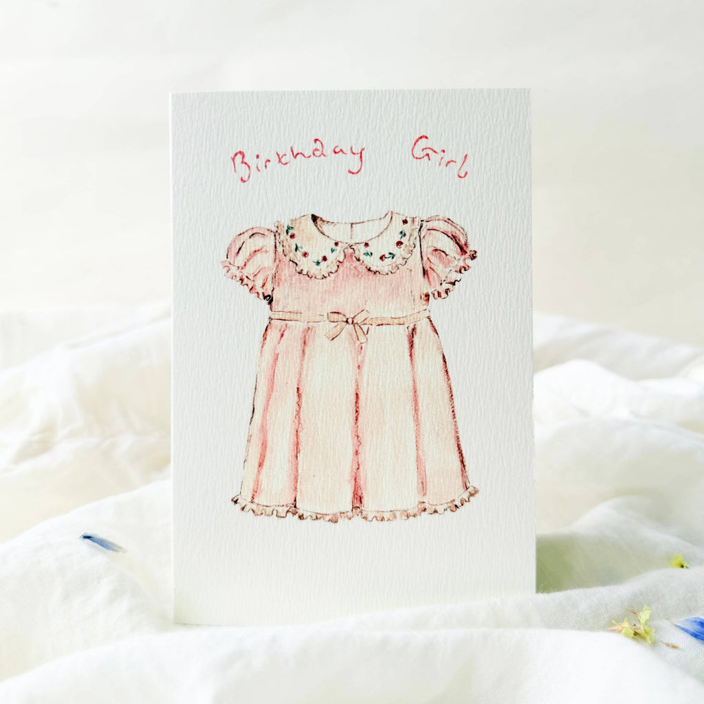 Greeting card with a pink dress illustration and 'Birthday Girl' text on a white background.