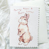 Greeting card with a bunny illustration and 'Bunny Kisses & Easter Wishes' text on a white textured background.