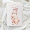 Card with a bunny illustration on a textured white surface