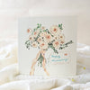 Card with a bouquet of flowers and 'Happy Anniversary' text on a soft white background