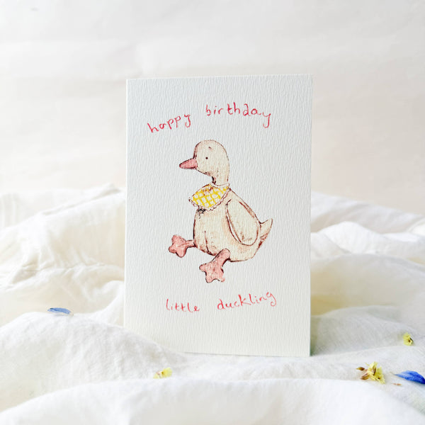 Birthday card with a duck illustration on a white surface