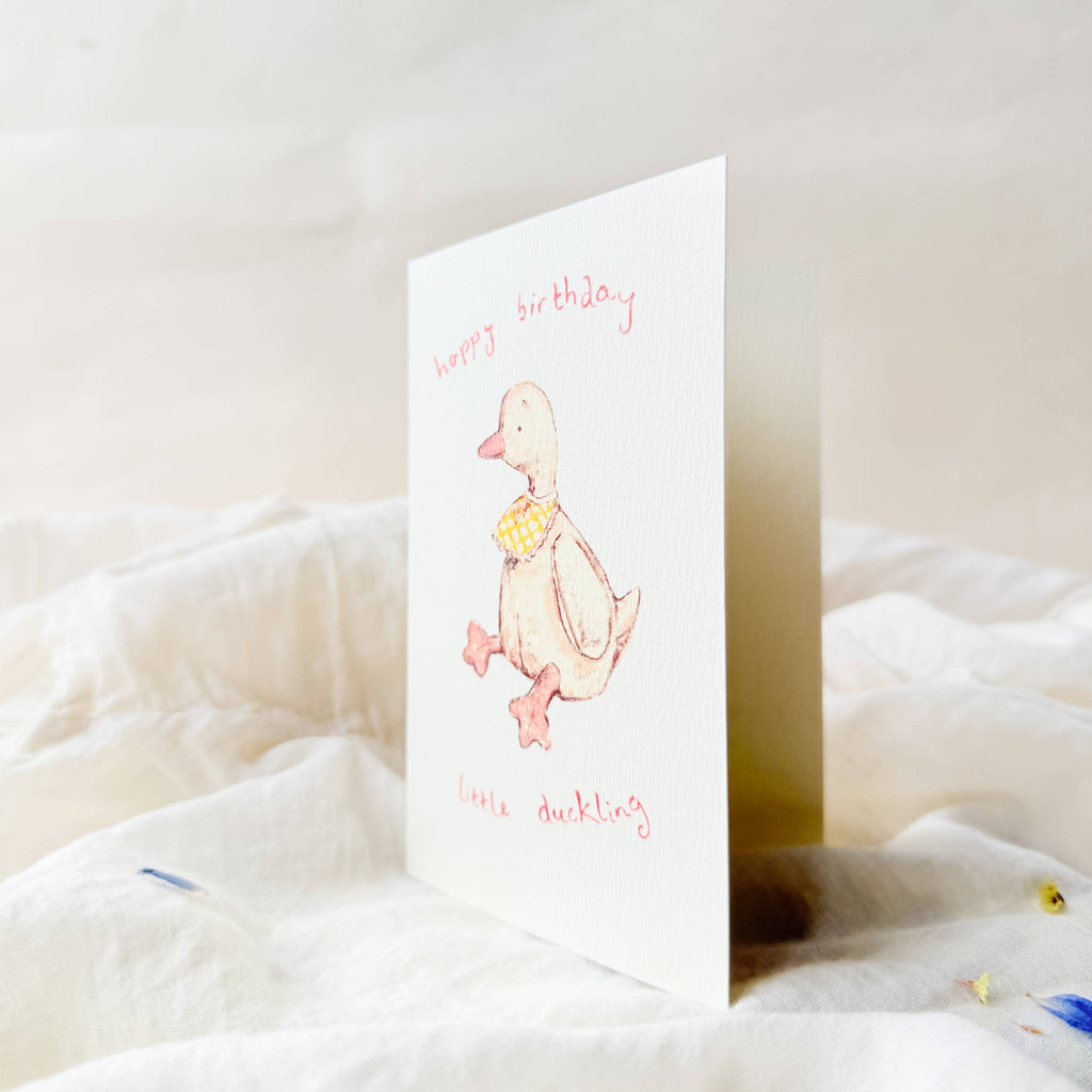Greeting card with a duck illustration on a white surface