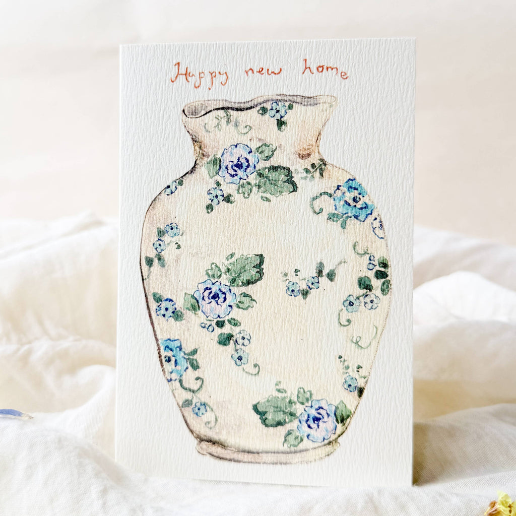 Card with a floral-patterned vase design and 'Happy new home' text on a soft white background.