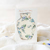 Card with floral vase design and 'Happy New Home' text on a soft white background