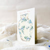 Greeting card with floral vase design on a white surface