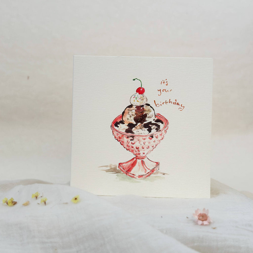 Greeting card with a pink ice cream sundae illustration on a white background
