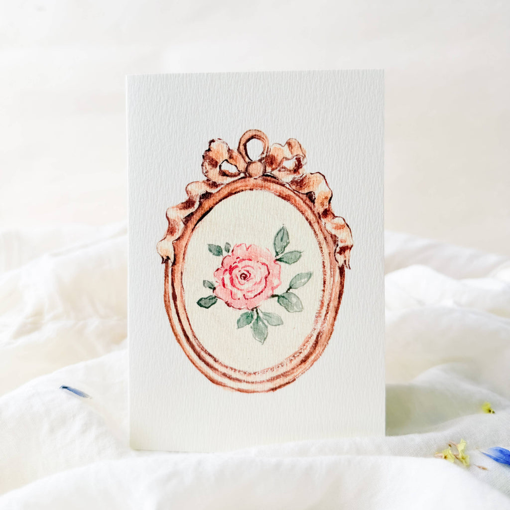 Decorative card with a rose design in a vintage frame on a white background