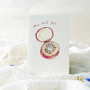 Card with an illustration of a ring box and 'She said yes' text on a white background