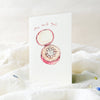Card with a pink ring box and 'she said yes' text on a white background