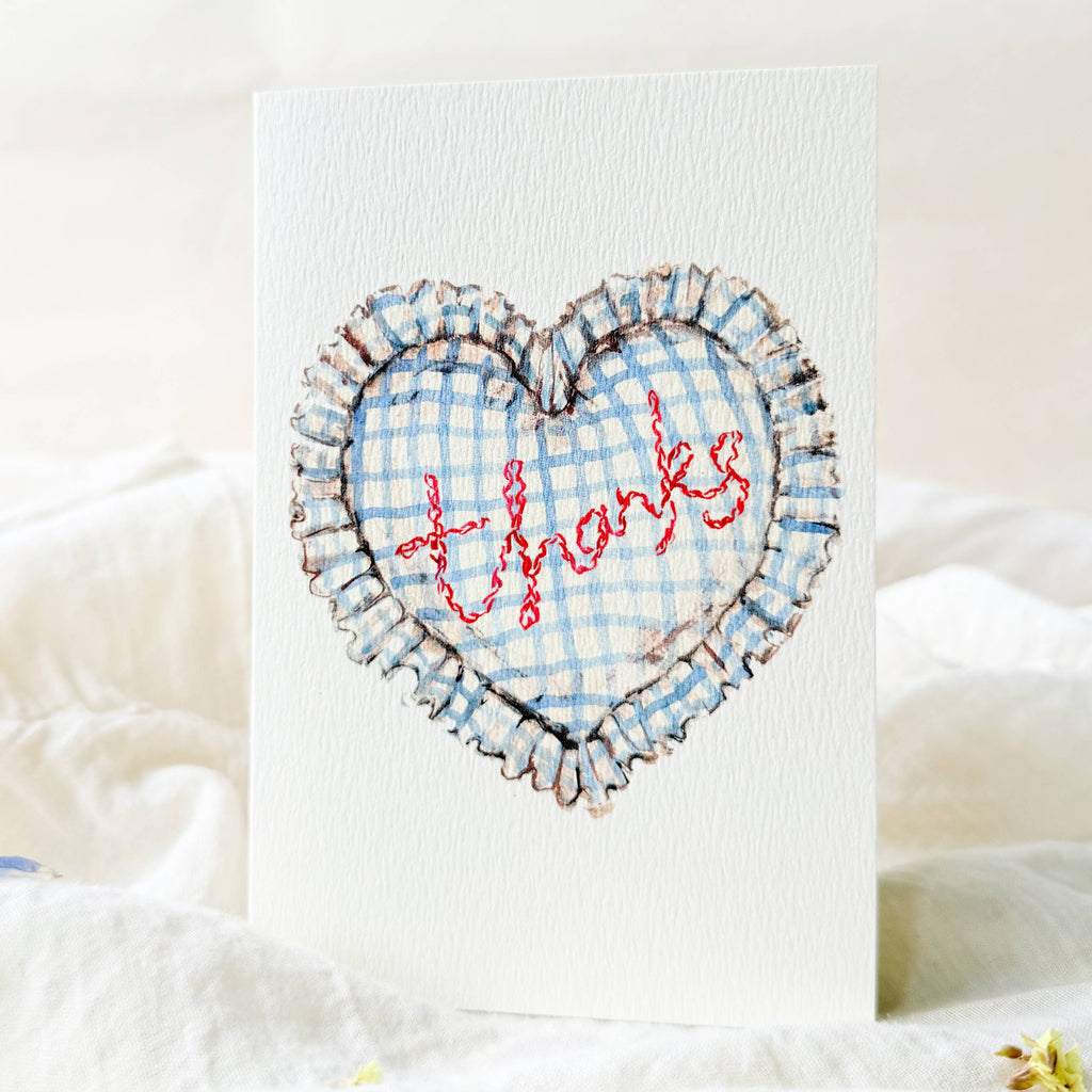 Heart-shaped card with 'Thanks' embroidery on a white background