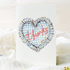 Heart-shaped card with 'Thanks' embroidery on a white background