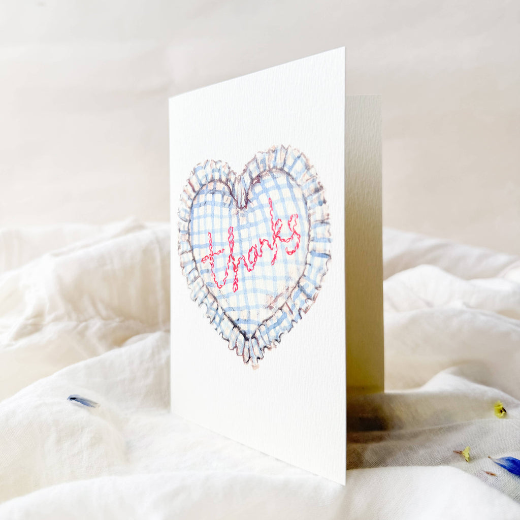 Greeting card with heart design and 'thanks' text on a white surface