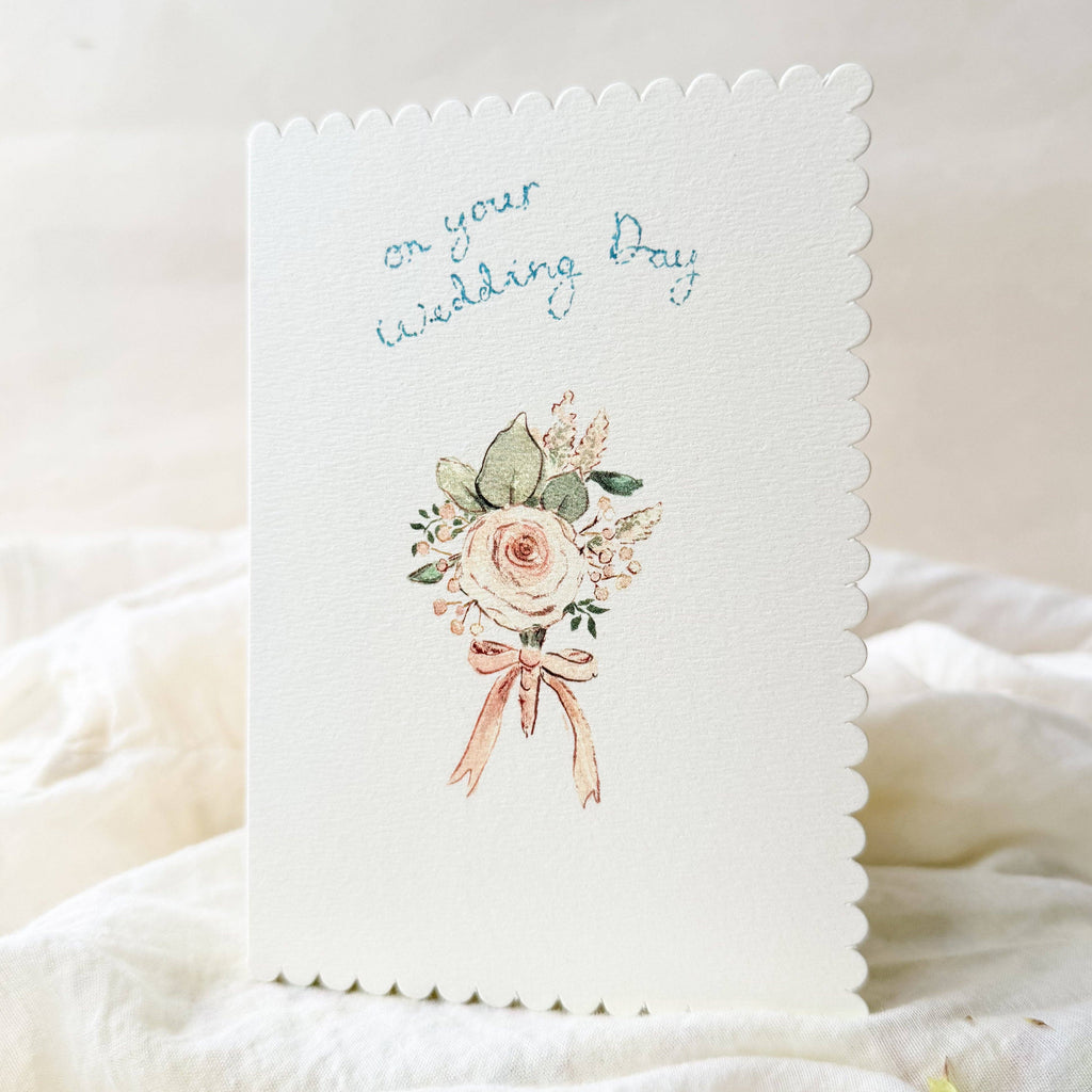 Wedding card with floral design and 'on your wedding day' text on a soft white background
