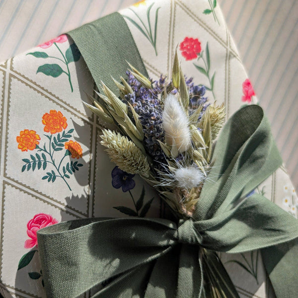 Floral-patterned fabric with a green ribbon and dried flowers