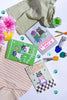 Three greeting cards with cat illustrations on a surface with stationery items.