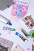 Colorful cat-themed cards and paint tubes on a white surface