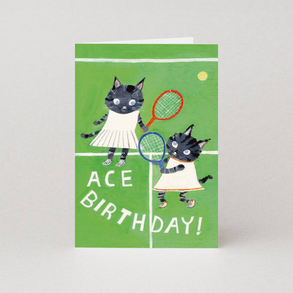 Birthday card with two cats playing tennis on a green background