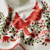 Embroidered design of red birds and flowers on a white fabric background