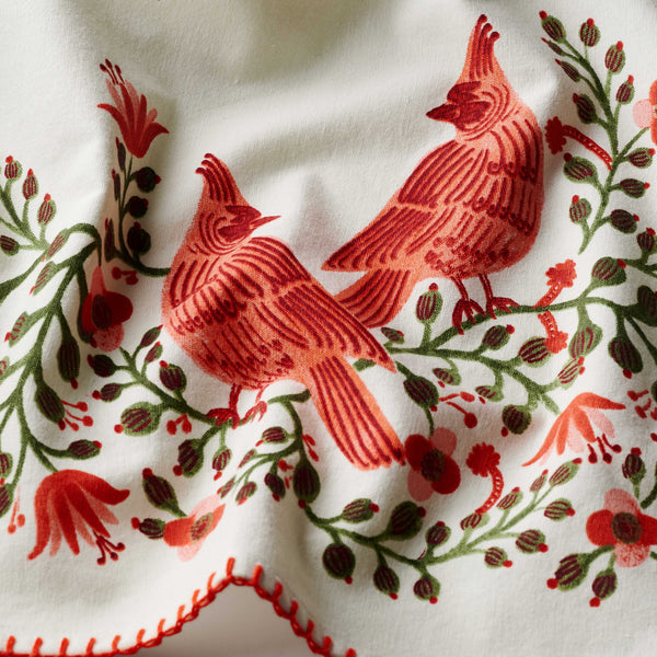 Embroidered design of red birds and flowers on a white fabric background