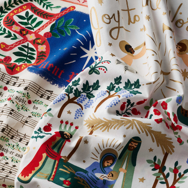 Decorative fabric with Christmas-themed designs featuring nativity scenes and festive elements.