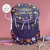 Decorative cake with 'Witches Don't Age' text and gold foil details on a pink background