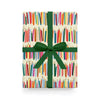 Gift box with colorful book pattern and green ribbon on a white background