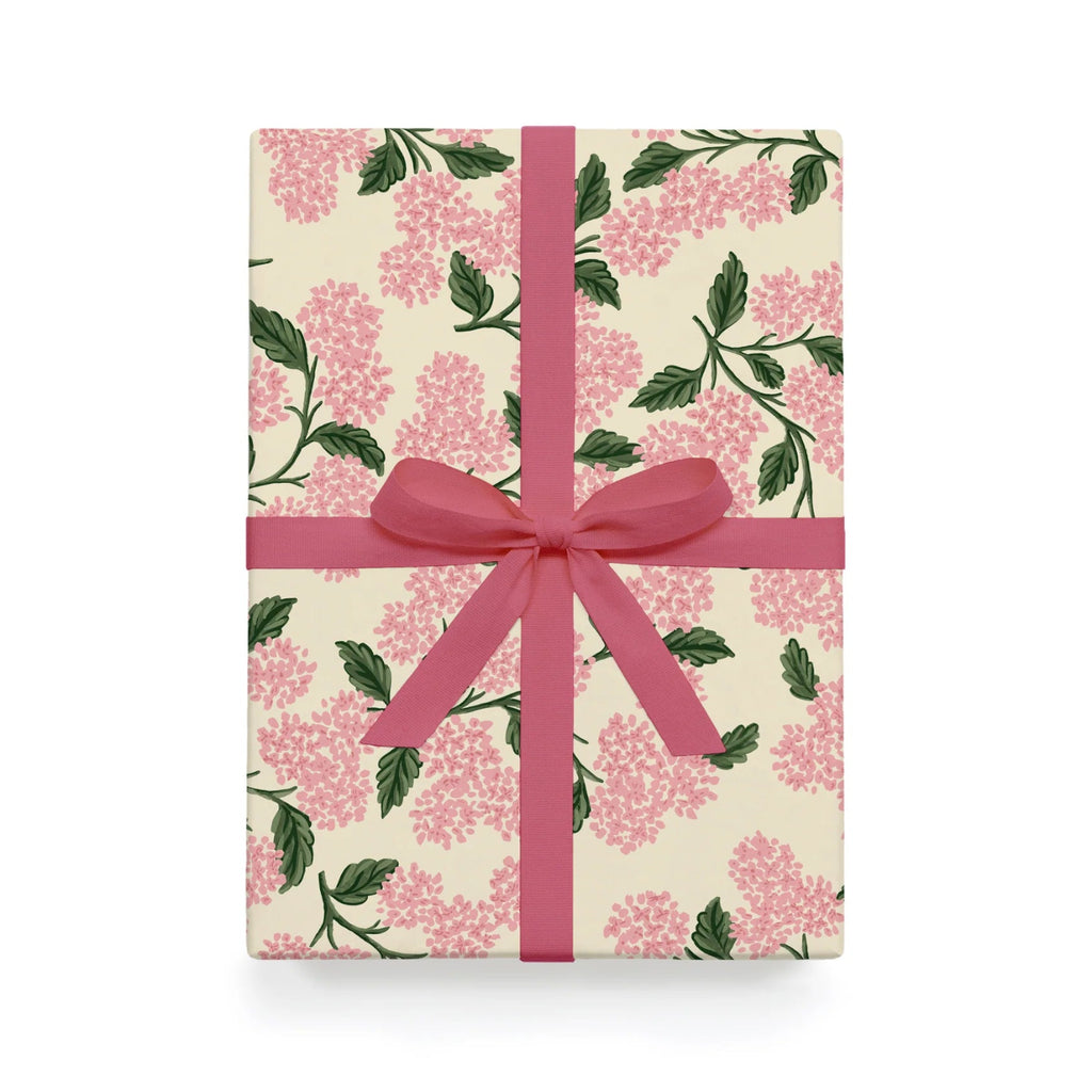 Gift box with floral pattern and pink ribbon on a white background