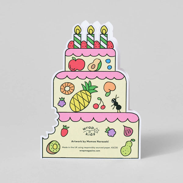 Sticker design of a cake with candles and fruits on a gray background