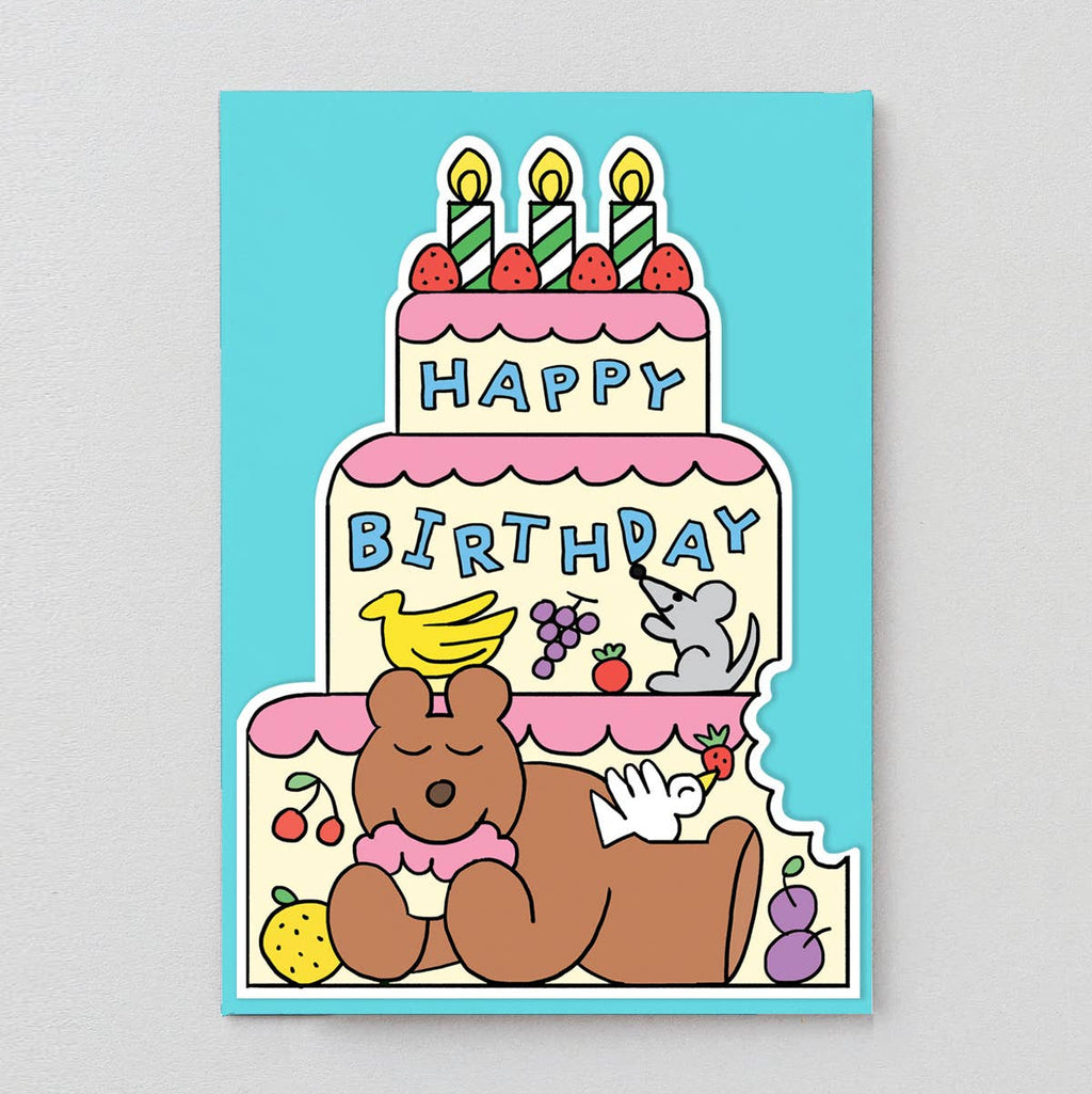 Cartoon birthday cake with candles and a bear on a blue background