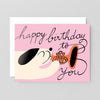 Birthday card with a dog blowing a trumpet on a pink background