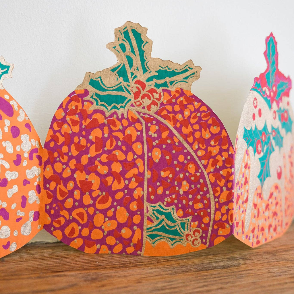 Colorful pumpkin-shaped cutouts on a wooden surface