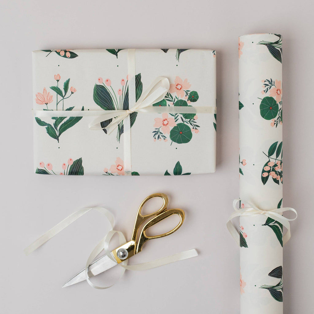 Floral-patterned gift wrap with scissors on a light gray background
