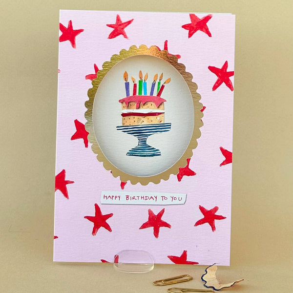 Birthday card with a cake illustration and red stars on a beige background