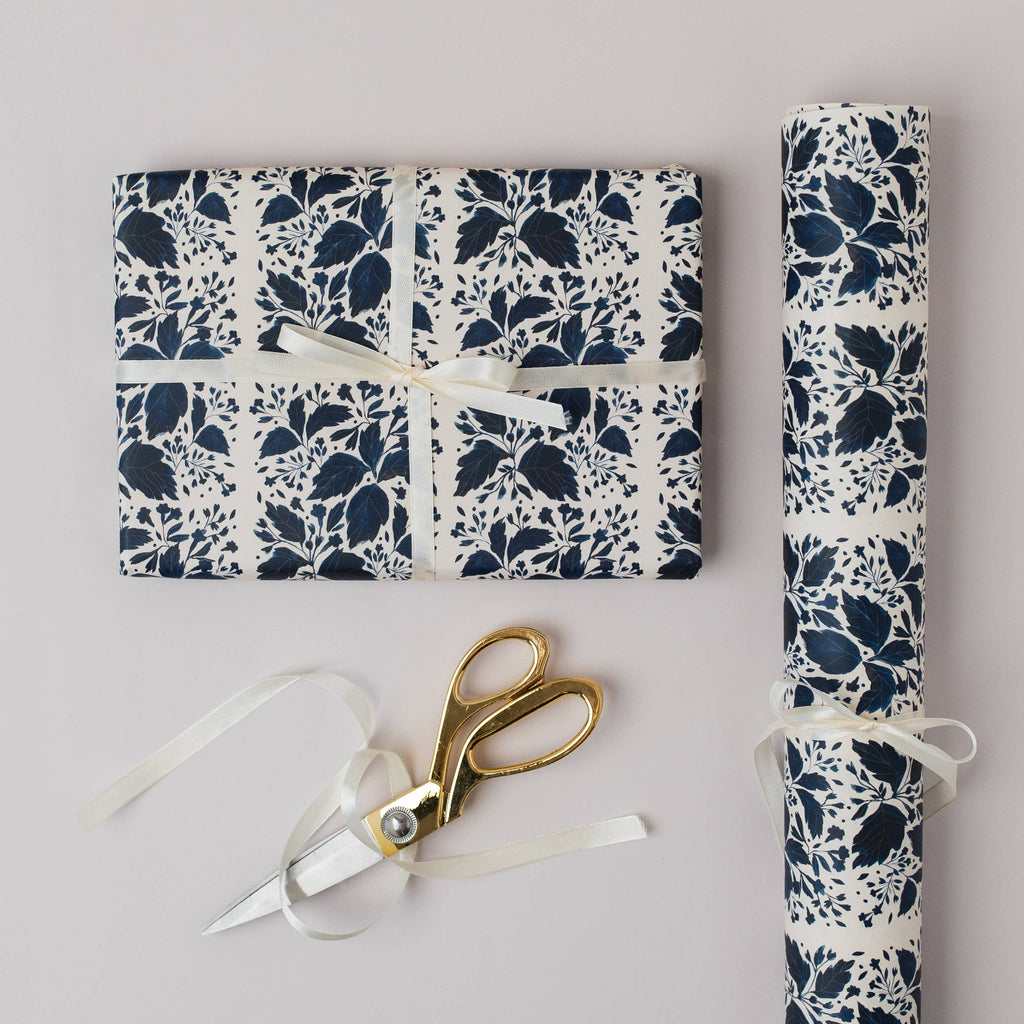 Floral-patterned gift wrap with scissors on a light gray background