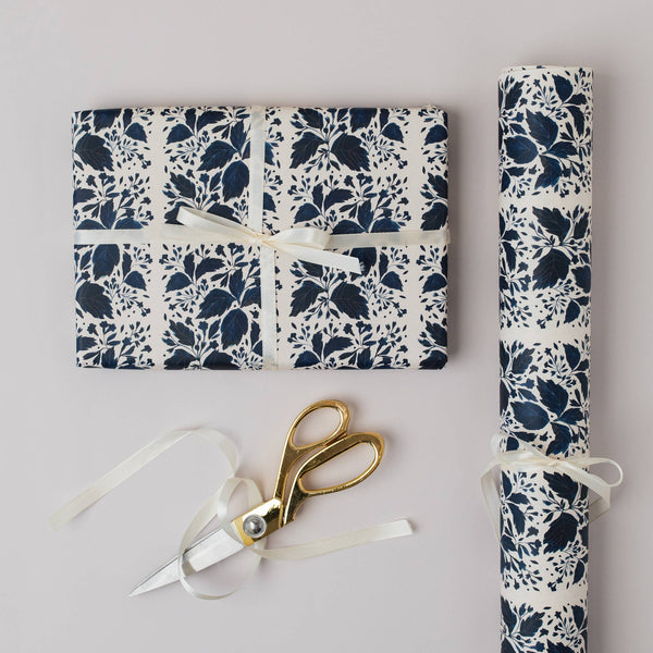 Floral-patterned gift wrap with scissors on a light gray background