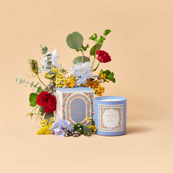 Candle with floral arrangement on a beige background