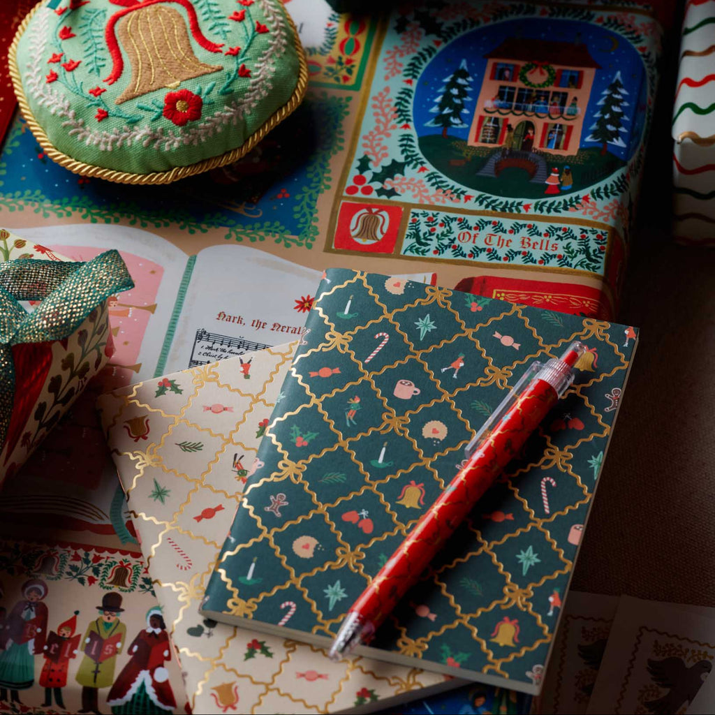 Decorative stationery items including a notebook, pen, and gift box on a colorful surface.