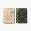 Two patterned notebooks, one beige with small illustrations and one green with geometric design, on a white background.