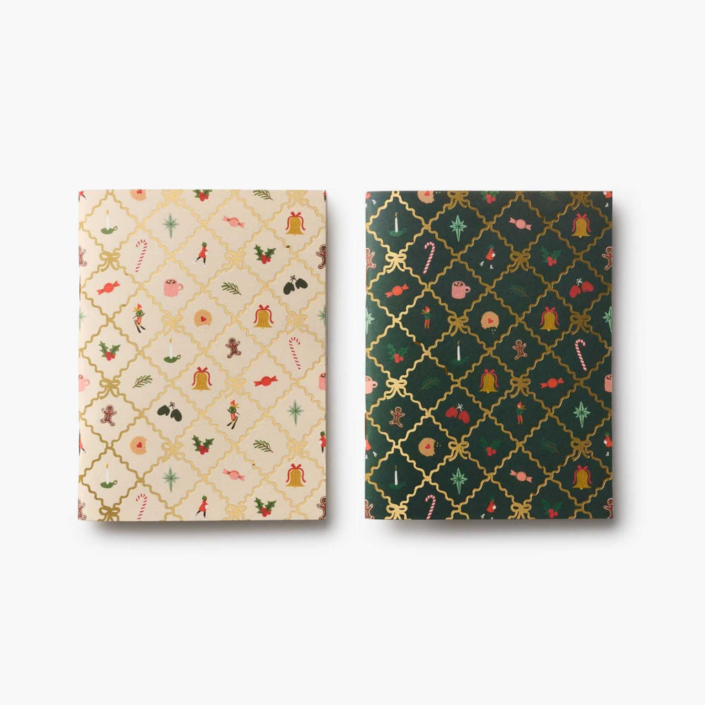 Two patterned notebooks, one beige with small illustrations and one green with geometric design, on a white background.