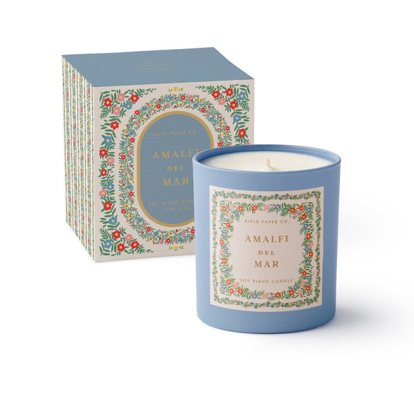 Blue candle with decorative label and matching box on a white background
