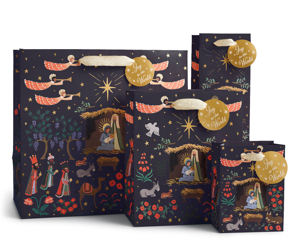 Set of Christmas-themed gift bags with nativity scene design on a dark background.